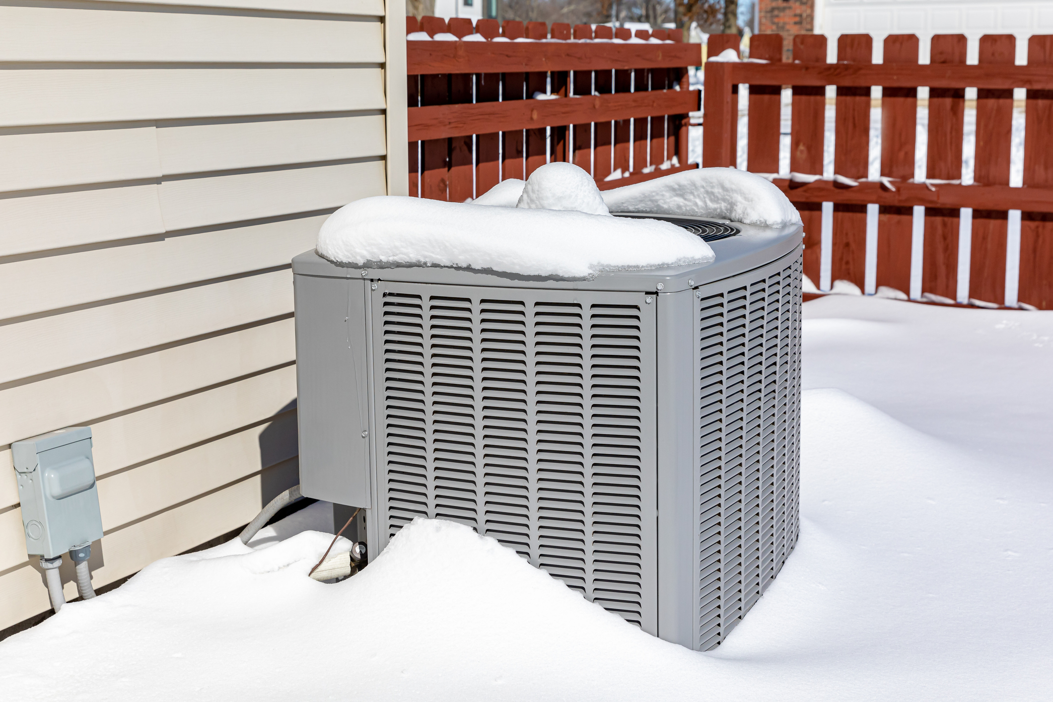 AC unit covered in snow outside a Wyoming home