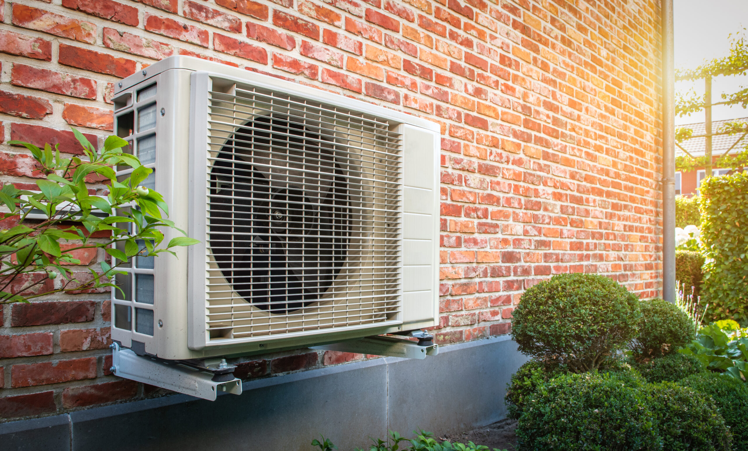 Heat pump system mounted on a brick wall in Greater Grand Rapids