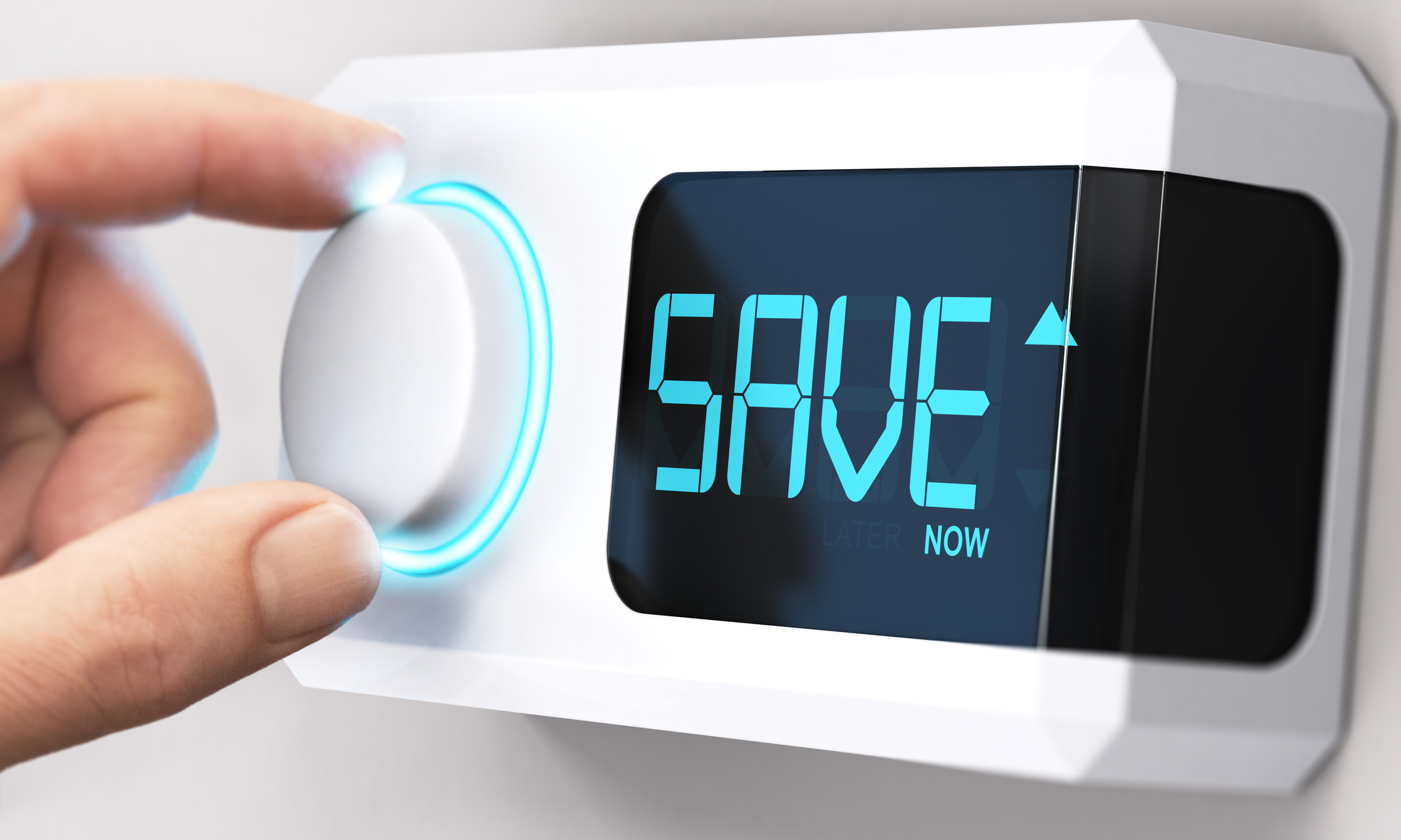 Hand on a thermostat knob that says “Save Now” on the face of the system