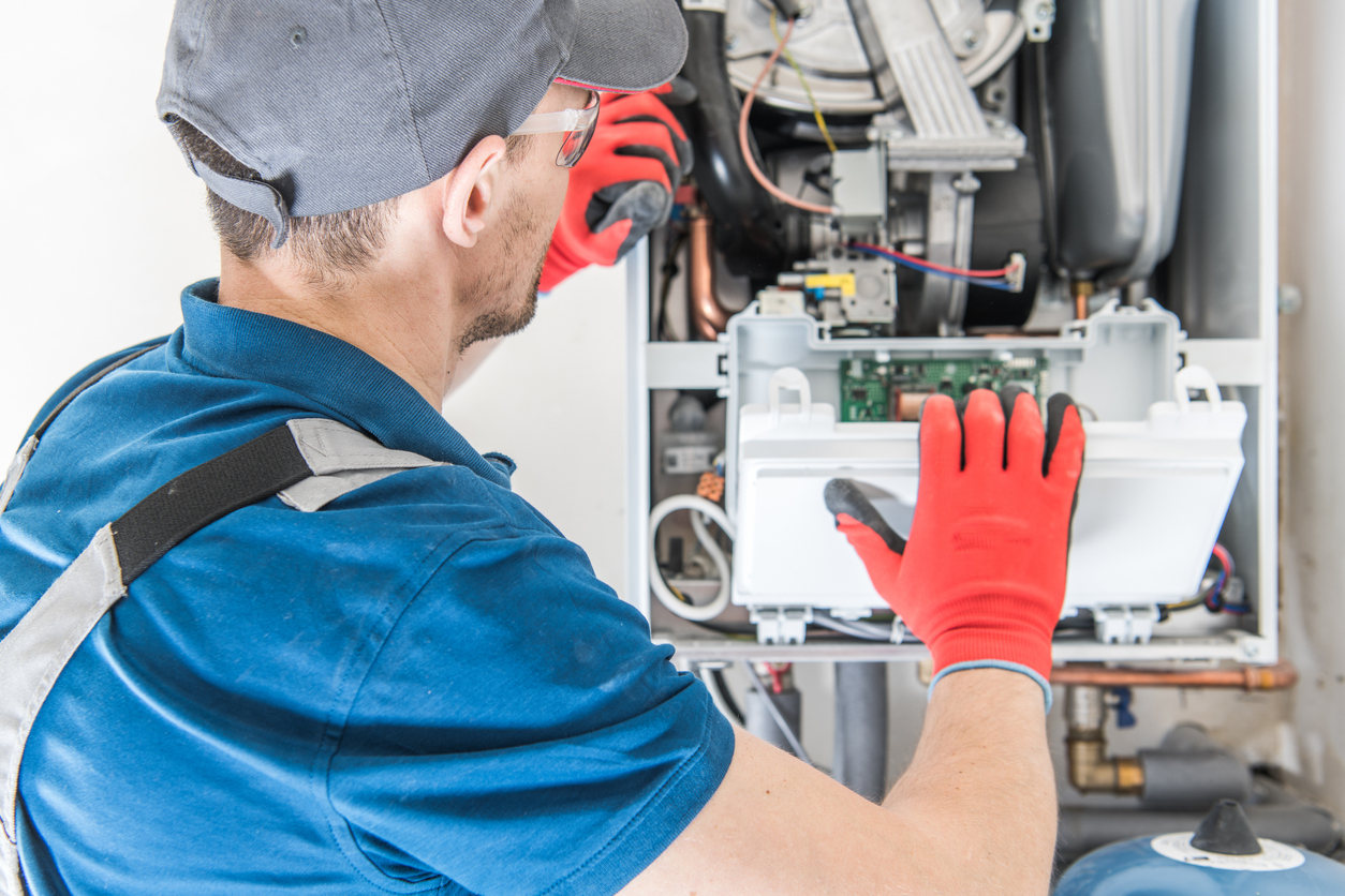 HVAC technician performing a tune-up service on a residential heating system
