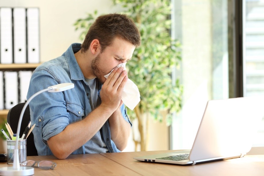 Man sneezing into a tissue because his house is full of allergens
